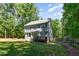 Spacious backyard featuring a manicured lawn, bordered by mature trees and greenery at 2209 Woodnell Dr, Raleigh, NC 27603