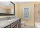 Bathroom with granite vanity, framed mirror and tiled tub/shower combo at 2209 Woodnell Dr, Raleigh, NC 27603