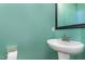 Stylish powder room with a modern pedestal sink and vibrant teal walls at 2209 Woodnell Dr, Raleigh, NC 27603