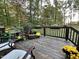 Deck with wooden floors, wooden railing, chairs, and plants, with a wooded landscape at 2209 Woodnell Dr, Raleigh, NC 27603