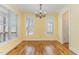 Bright dining room with hardwood floors, chandelier and ample natural light from two windows at 2209 Woodnell Dr, Raleigh, NC 27603