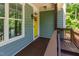 Close up of a cozy front porch with a bright yellow door and classic details at 2209 Woodnell Dr, Raleigh, NC 27603