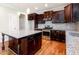 Stylish kitchen featuring dark wood cabinets, stainless steel appliances, and a granite island at 2209 Woodnell Dr, Raleigh, NC 27603