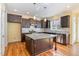 Kitchen features a granite countertop island, stainless steel appliances, and dark wood cabinets at 2209 Woodnell Dr, Raleigh, NC 27603