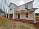 New two-story home boasts white siding, covered porch, and an attached two-car garage at 2868 Stoney Creek Church Rd, Burlington, NC 27217