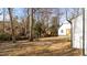 Backyard view of a home with new wooden deck, white siding and mature trees at 2908 Basswood Dr, Raleigh, NC 27610