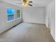 Neutral bedroom with carpet, a ceiling fan, and large windows allowing ample natural light at 3300 Mossdale Ave, Durham, NC 27707