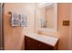 Bathroom featuring peach walls, a dark wood vanity with sink, large mirror, and decorative hand towels at 3320 Derbyshire Pl, Raleigh, NC 27604