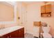 Well-lit bathroom featuring peach walls, a dark wood vanity, and ceramic tile floors at 3320 Derbyshire Pl, Raleigh, NC 27604