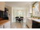 Bright eat-in kitchen boasts white cabinetry, butcher block countertops, a farmhouse sink, and bay window with dining set at 3320 Derbyshire Pl, Raleigh, NC 27604