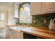 Modern kitchen featuring white cabinets, butcher block countertops, and a farmhouse sink at 3320 Derbyshire Pl, Raleigh, NC 27604