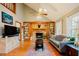 Spacious living room featuring hardwood floors, built-in bookshelves, and a brick fireplace at 3320 Derbyshire Pl, Raleigh, NC 27604