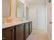 Bathroom with double sink vanity with dark cabinets and gold framed mirrors at 416 Granite Saddle Dr, Rolesville, NC 27571