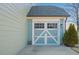 View of attached garage with carriage door design, showing detail and matching exterior paint at 416 Granite Saddle Dr, Rolesville, NC 27571