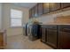 Functional laundry room with a window, washer, dryer, and ample cabinet space at 416 Granite Saddle Dr, Rolesville, NC 27571