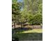 Landscaped backyard view featuring privacy-enhancing trees and a classic black metal fence at 468 Talons Rest Way, Cary, NC 27513