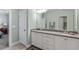 Well-lit bathroom featuring dual sinks, white cabinets, and access to a bedroom at 468 Talons Rest Way, Cary, NC 27513