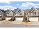 Inviting townhomes showcasing attached garages, stone details, and well-manicured landscaping on a sunny day at 468 Talons Rest Way, Cary, NC 27513