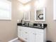 Bathroom featuring dual sink vanity with granite counters, wood cabinets, and mirrors at 4704 Upchurch Ln, Wake Forest, NC 27587