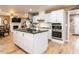 Modern kitchen with white cabinets, stainless steel appliances, and a large island with granite countertop at 4704 Upchurch Ln, Wake Forest, NC 27587