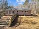 Backyard view showing an expansive deck, lawn, and mature trees at 5614 Greenbay Dr, Durham, NC 27712