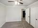 This bedroom features neutral walls, gray carpet, closet and ceiling fan with light at 5614 Greenbay Dr, Durham, NC 27712