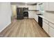 Well-lit kitchen featuring stainless steel appliances, white cabinets, countertops and stylish flooring at 5614 Greenbay Dr, Durham, NC 27712