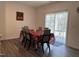 A dining room features a sliding glass door with blinds, wood floors, and seating for six at 704 Mirror Pond Dr, Zebulon, NC 27597