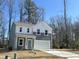 Charming two-story home with gray and white siding, a two-car garage, and a well-manicured front lawn at 704 Mirror Pond Dr, Zebulon, NC 27597