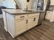 A kitchen island features granite counters, stainless steel appliances, and white cabinets at 704 Mirror Pond Dr, Zebulon, NC 27597
