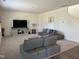 A bright living room features two sofas, carpet floors, and a stairway leading to the second floor at 704 Mirror Pond Dr, Zebulon, NC 27597