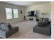 A spacious living room is furnished with two gray sofas, a TV, and two windows for natural light at 704 Mirror Pond Dr, Zebulon, NC 27597