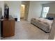A main bedroom features a dresser, tufted bed, carpet floors, and an ensuite bathroom at 704 Mirror Pond Dr, Zebulon, NC 27597