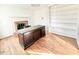 Home office with hardwood floors, fireplace, built-in shelving, and large desk at 708 Macon Pl, Raleigh, NC 27609