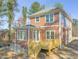 Two-story house with an open wood deck and a green roof with trees nearby at 717 Heidelberg St, Durham, NC 27704