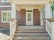 Close-up of the front porch of a charming brown home with brick-base columns and white trim at 717 Heidelberg St, Durham, NC 27704