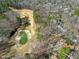 An aerial view of the home adjacent to a golf course with sand traps and pond at 103 Bruce Dr, Cary, NC 27511