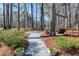 Landscaped backyard featuring stone pathway, mature trees, seating arrangement, and a wooden swing at 103 Bruce Dr, Cary, NC 27511