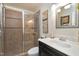 Modern bathroom featuring sleek glass door shower, dark vanity, and decorative mirror and artwork at 103 Bruce Dr, Cary, NC 27511