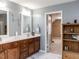 Bright bathroom featuring double vanities, marble floors, and an open doorway at 108 Leafy Holly Dr, Holly Springs, NC 27540