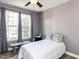 Bedroom with neutral wall color, two windows, and minimalist furnishings with natural light at 108 Leafy Holly Dr, Holly Springs, NC 27540