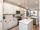 Modern kitchen featuring white cabinets, stainless steel appliances, and quartz countertops at 108 Leafy Holly Dr, Holly Springs, NC 27540