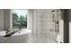 Bright bathroom with a freestanding tub, a walk-in shower, and a large window at 1104 Tobacco Row Ct, Zebulon, NC 27597