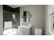 Modern bathroom showcasing vanity with gray cabinetry and a framed mirror over the sink at 1104 Tobacco Row Ct, Zebulon, NC 27597