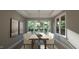 Elegant dining room with a stylish table, modern lighting, and large windows with backyard view at 1104 Tobacco Row Ct, Zebulon, NC 27597