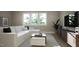 Bright living room with a large sectional sofa, modern entertainment center, and natural lighting at 1104 Tobacco Row Ct, Zebulon, NC 27597
