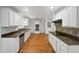 A large kitchen features stainless appliances, white cabinets, and stone countertops at 11308 Leesville Rd, Raleigh, NC 27613