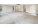Large, carpeted living room with ceiling fan and multiple entry points at 11308 Leesville Rd, Raleigh, NC 27613