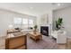 Cozy living room with fireplace, large windows, neutral colors, and hardwood floors at 126 Belmont Stakes Ln, Wendell, NC 27591