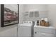 Bright laundry room with white washer and dryer, shelving, and decorative accents at 1305 White Verona Way, Knightdale, NC 27545